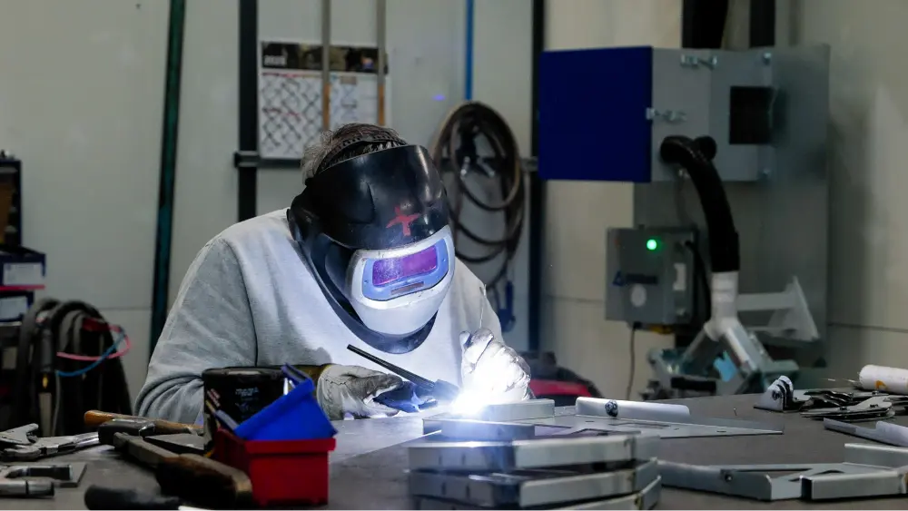 opérateur en atelier ATPA entrain de faire une soudure sur de l'acier